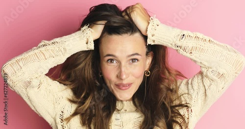 Happy woman looking camera shocked surprised say wow put hands on face, touch her hair. Wow, it is awesome. Surprised girl face. Close up of shocked woman face expression isolated on pink background.