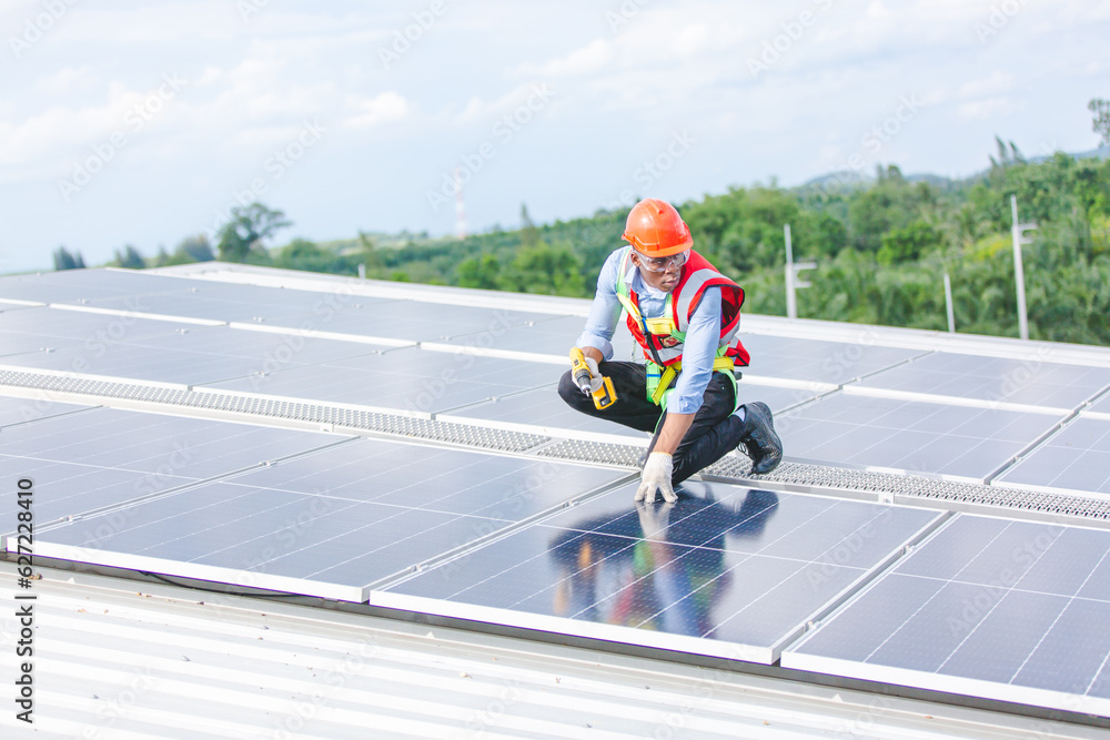African American engineer maintaining solar cell panels on factory building rooftop. Technician working outdoor on ecological solar farm construction. Renewable clean energy technology concept African American engineer maintaining solar cell panels on factory building rooftop. Technician working outdoor on ecological solar farm construction. Renewable clean energy technology concept