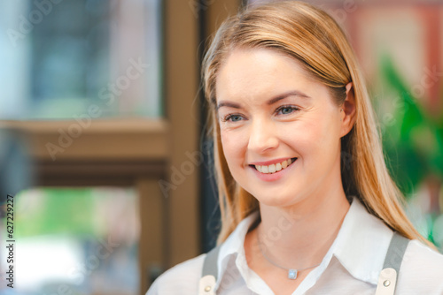 Smiling waitress wear apron take order talk to clients serving restaurant guests choosing food drinks menu in cafe coffeehouse bar, waiting staff, good customer service, cashier serving customers