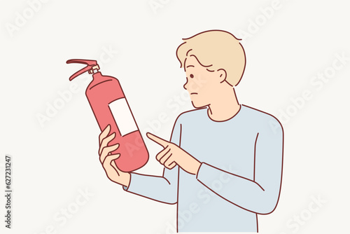 Man holds fire extinguisher checking expiration date equipment for extinguishing flame in emergency