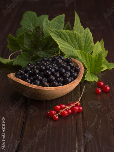 black currant and red currant on a wooden background.