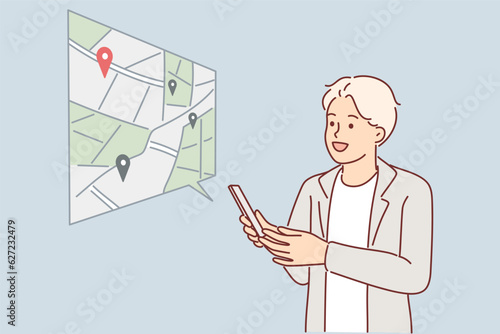 Man uses navigator on phone and builds route on map or looks for location of institution of interest