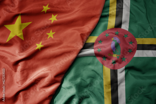 big waving national colorful flag of china and national flag of dominica .