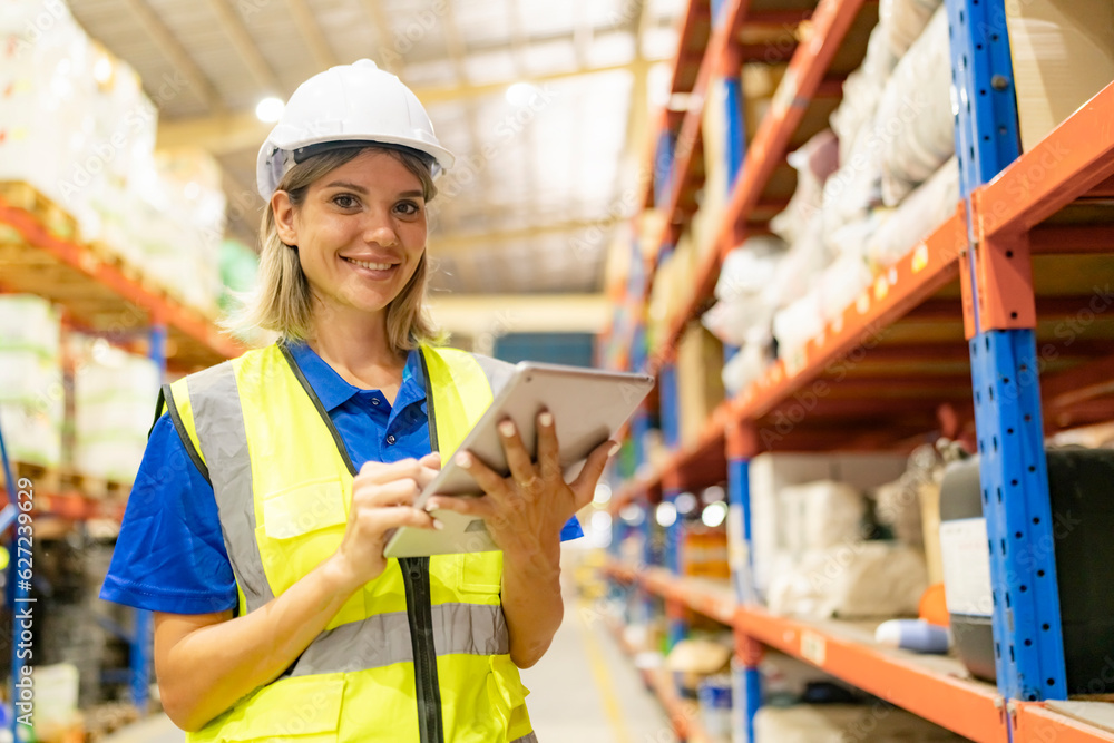Worker working in large warehouse holding paper chart check list checking the material compare with the boxes wrapped with plastic keep on wooden pallet ready to ship to customer Worker working in large warehouse holding paper chart check list checking the material compare with the boxes wrapped with plastic keep on wooden pallet ready to ship to customer