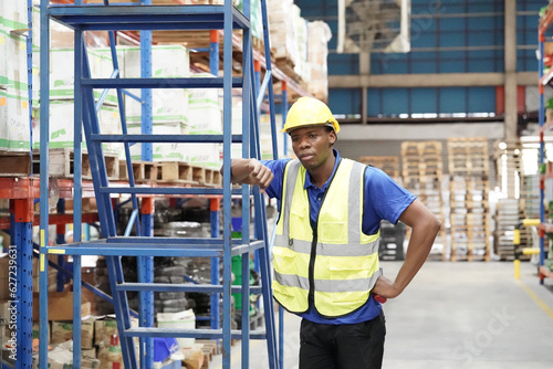 Worker working in large warehouse holding paper chart check list checking the material compare with the boxes wrapped with plastic keep on wooden pallet ready to ship to customer © FotoArtist