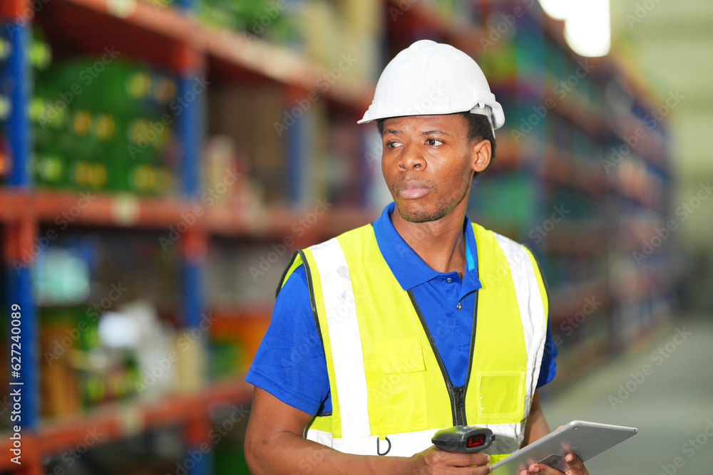 Fototapeta premium Worker working in large warehouse holding paper chart check list checking the material compare with the boxes wrapped with plastic keep on wooden pallet ready to ship to customer