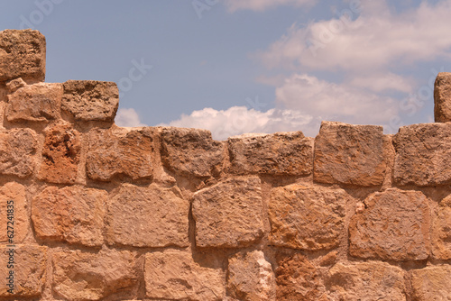 Muro a blocchi di arenaria sotto un cielo azzurro photo