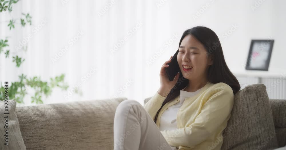 아늑한 소파에 앉아 통화하며 여행 계획을 이야기하는 젊은 여성