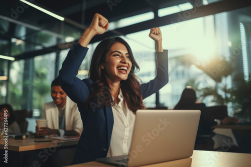 woman with laptop in office,in a gesture of joyful arms outstretched