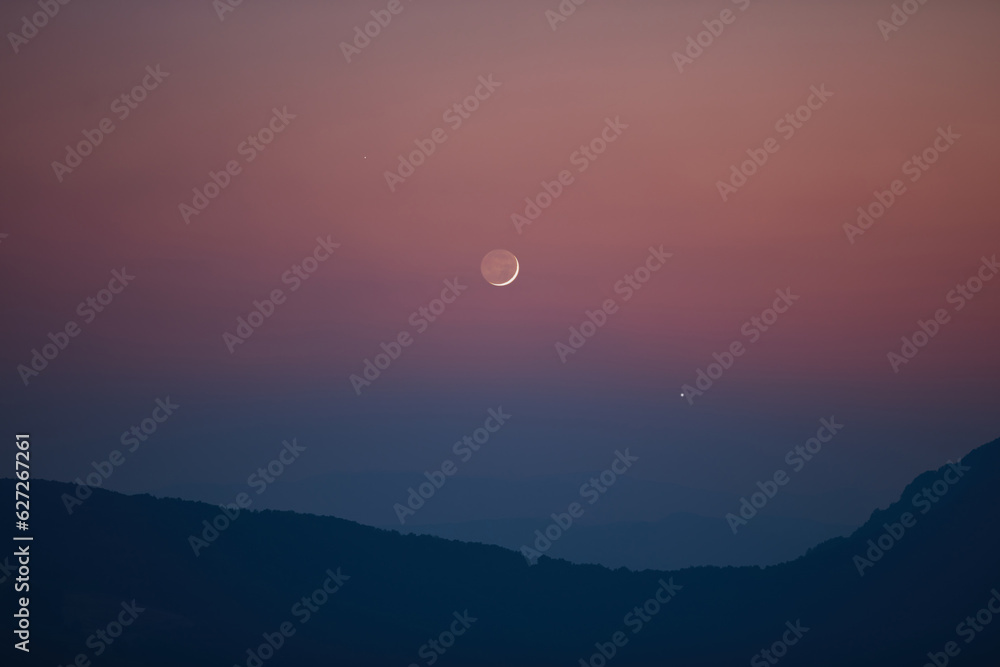 Silhouette of a countryside with Milky Way stars, planets and crescent Moon. Silhouette of a countryside with Milky Way stars, planets and crescent Moon.