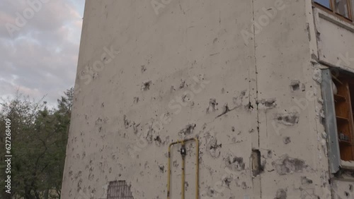 Traces from the arrival of mines and artillery shells on the wall of a residential building. Irpin, Ukraine