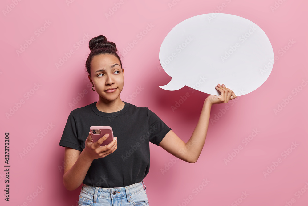 Φωτογραφία Photo of thoughtful Latin woman with hair gathered in bun holding empty speech b