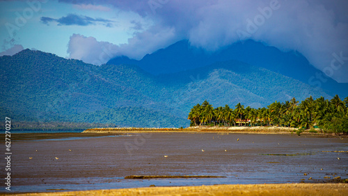 panorama of beautiful, idyllic tropical beach in cardwell, sandy beach with the view of mighty mountains in hinchinbrook island; north queensland, australia photo