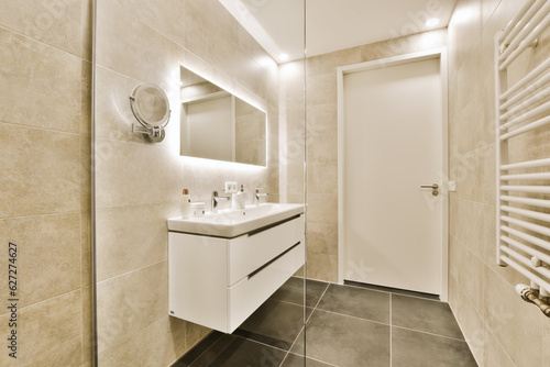 a modern bathroom with tile flooring and white fixtures on the wall  mirror in the corner to the left