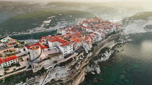 Aerial morning view of Bonifacio, Corsica island. Houses on cliff in the rays of rising sun in Bonifacio old town, Corsica, France. Mediterranean sea