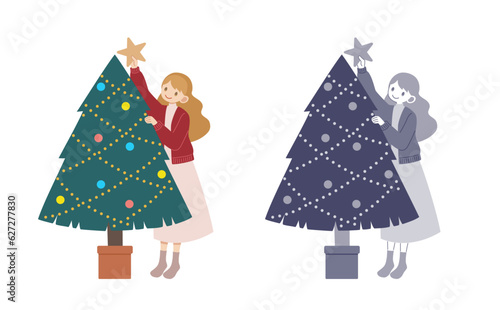 クリスマスツリーに星を飾る女性