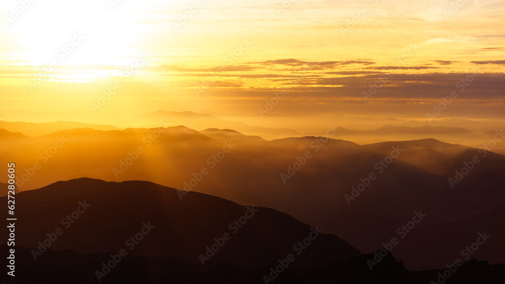 amazing landscape of mountains in silhouette at sunset, backlit with fog. Sierra del Aramo in Asturias, Spain. Mountain range.