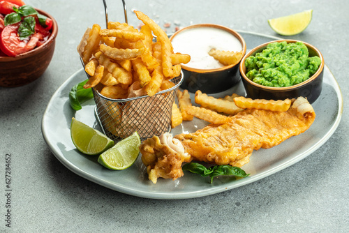 Traditional english dish fish and chips served with mashed peas, tartar sauce, Traditional British food