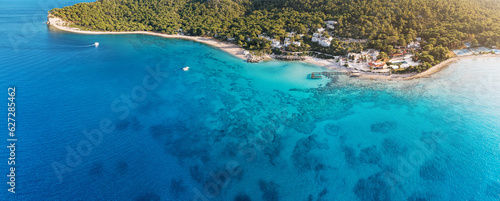 Aerial view of the paradisiacal idyllic coast with a beach and a small resort hotel