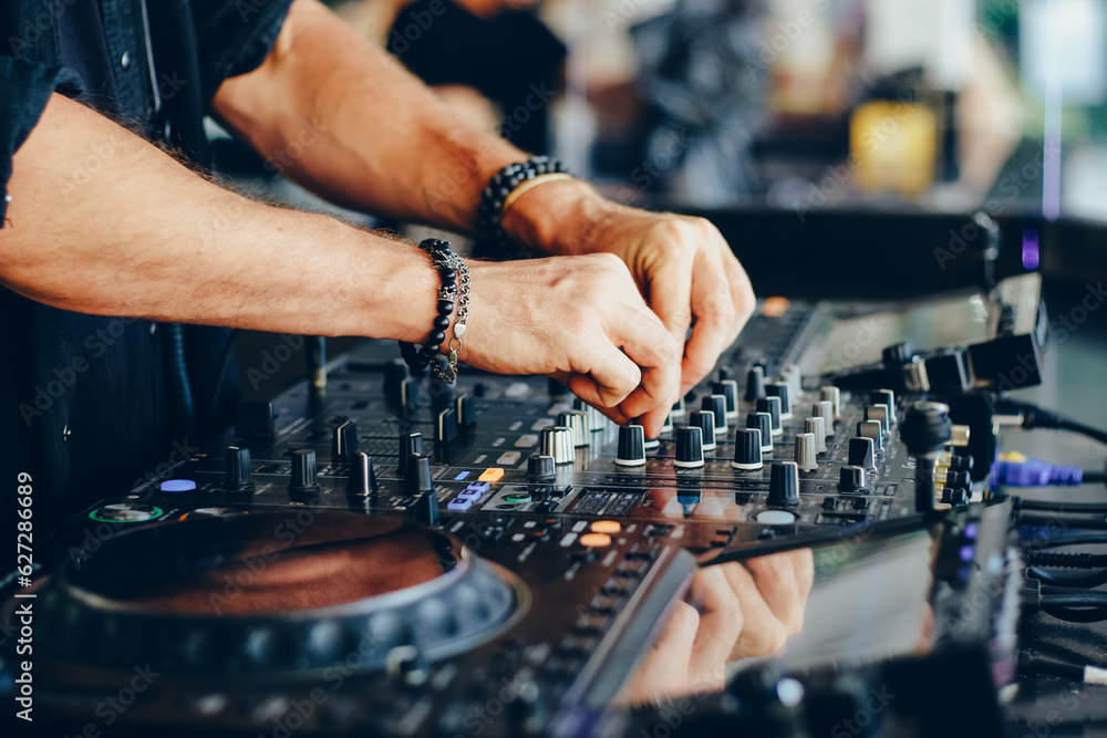 Hands of a DJ working with a mixing console close-up. Hands of a DJ working with a mixing console close-up.