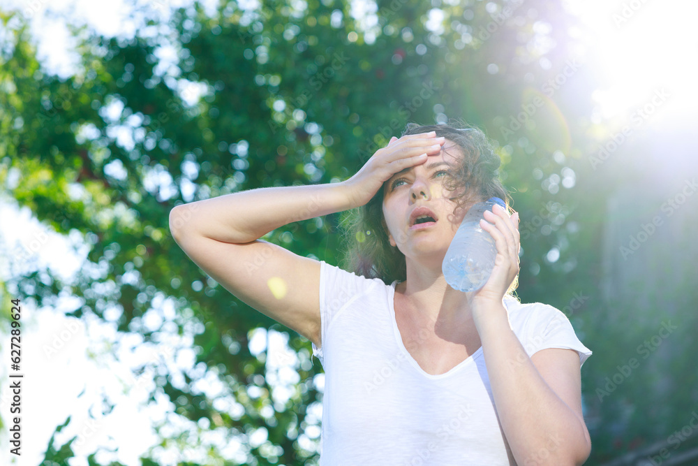 Young woman having hot flash and sweating in a warm summer day Young woman having hot flash and sweating in a warm summer day