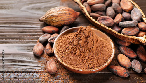 Cocoa powder and cocoa beans on wooden background