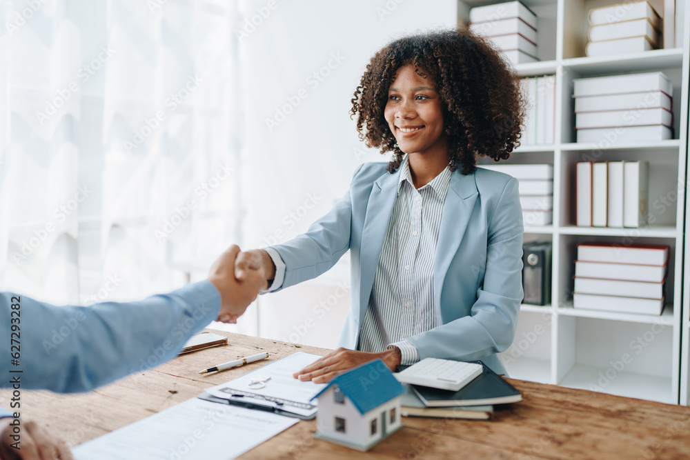The bank's Female African american Mortgage Officers shake hands with customers to congratulate them after signing a housing investment loan agreement The bank's Female African american Mortgage Officers shake hands with customers to congratulate them after signing a housing investment loan agreement