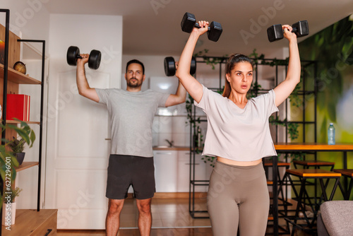 Couple doing biceps exercises with dumbbels
