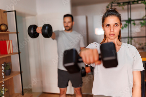 Couple doing arm workout using dumbbells