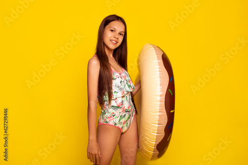 friendly teen girl training in summer camping for children in swimming pool concept over yellow background © cenchild