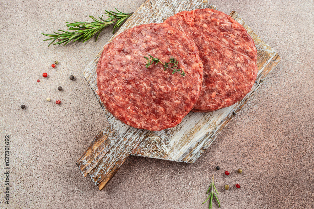 Raw cutlet for burger on a dark background, Restaurant menu, dieting, cookbook recipe top view Raw cutlet for burger on a dark background, Restaurant menu, dieting, cookbook recipe top view