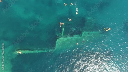 Drone footage of people swimming next to a sunken ship  in Elba Island, Tuscany, Italy