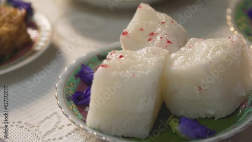 Phuket native desserts, Kanom Pae Tung Koi or Sticky rice cake made from rice flour and white sugar. The texture of the snack is white puffy prunes with red dots on the front. photo