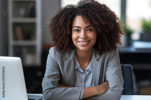 Confident African American woman smiling proudly at her office desk, facing the camera with a computer nearby, generative ai