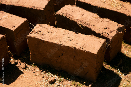 Man building with his hands an adobe house with adobe bricks and mud. Llachon region of Lake Titicaca in Peru. photo