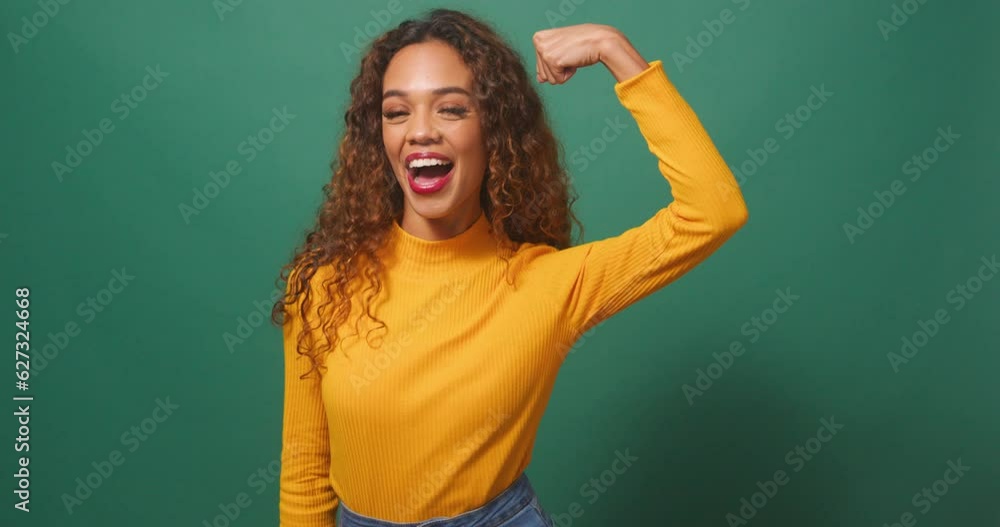 Powerful strong woman flexes arm muscle, winks smiles, greens studio background Powerful strong woman flexes arm muscle, winks smiles, greens studio background