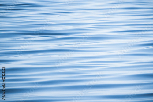 Blue water surface with a pattern of soft waves, background