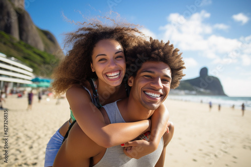 Portrait of a young Brazilian black couple in a piggyback position, having fun at the beach. © Creative Clicks