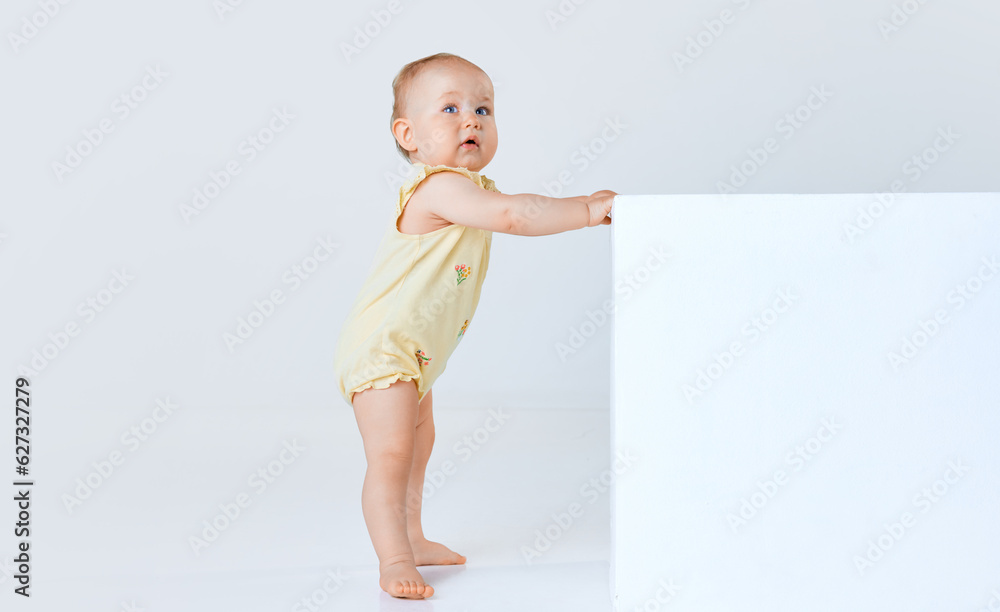 Adorable little baby girl, child, toddler in comfortable cute clothes standing and looking against grey studio background. Concept of childhood, family, lifestyle, happiness, care. Copy space for ad Adorable little baby girl, child, toddler in comfortable cute clothes standing and looking against grey studio background. Concept of childhood, family, lifestyle, happiness, care. Copy space for ad