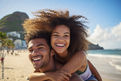 Portrait of a young Brazilian black couple in a piggyback position, having fun at the beach.