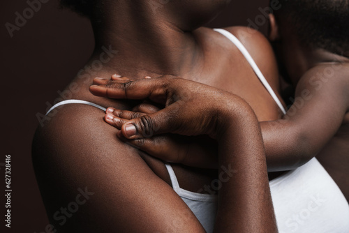 Closeup photo of black woman holding her son's hand