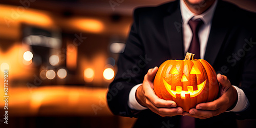 Businessman showing a pumpkin in the holiday halloween