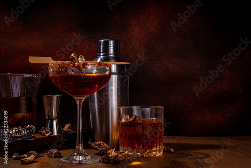 

Trendy hard alcohol mushroom cocktail, booze-free mushroom infused drinks in various cocktail glasses, with bar utensils on dark wooden background copy space