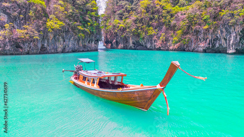 Tourist long tail boat Landed on a peaceful beach, clear water, surrounded by hills of Koh Phi Phi, Thailand © munduuk