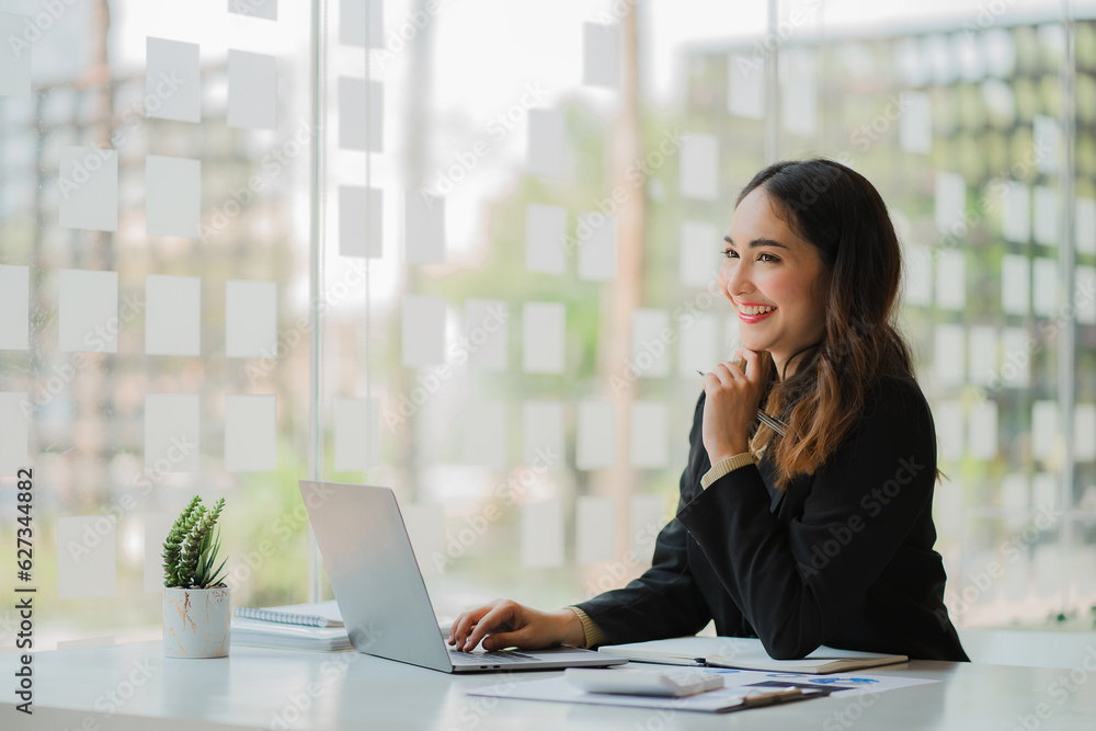 Asian businesswoman working online with financial documents and laptop on table in office Finance and Business Accounting business training concept Asian businesswoman working online with financial documents and laptop on table in office Finance and Business Accounting business training concept