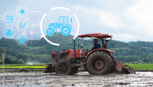 IOT smart industry robot 4.0 agriculture concept.Autonomous tractor working in farm.Smart farming and digital transformation in agriculture. Controls autonomous tractor in farm.