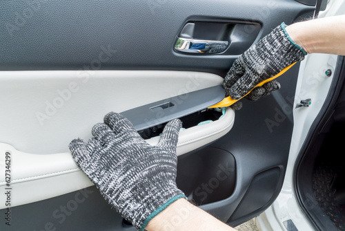Auto mechanic remove car window controls panel, Car maintenance service.