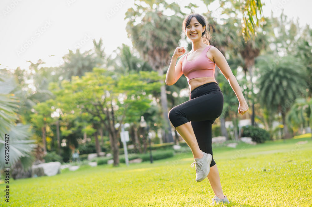 concept of wellness and well-being fit 30s Asian woman wearing pink sportswear exercising in public park at sunset. healthy outdoor lifestyle, wellness and well-being.