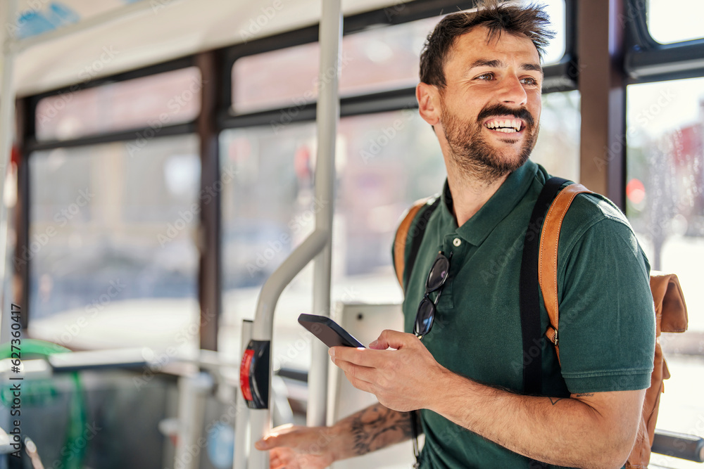 A happy commuter with a phone is riding a public transport. A happy commuter with a phone is riding a public transport.