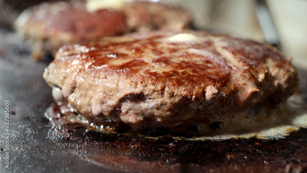 Macro shot of roasting juicy burger patties on grill at kitchen. Cooking at home, kitchen appliance, healthy nutrition, hamburger ingredients. Macro shot of roasting juicy burger patties on grill at kitchen. Cooking at home, kitchen appliance, healthy nutrition, hamburger ingredients.